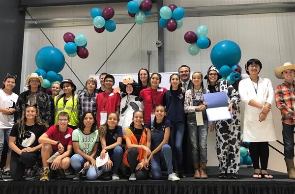 Photo of group of junior high students and their teachers underneath a balloon arch Photo of group of junior high students and their teachers underneath a balloon arch